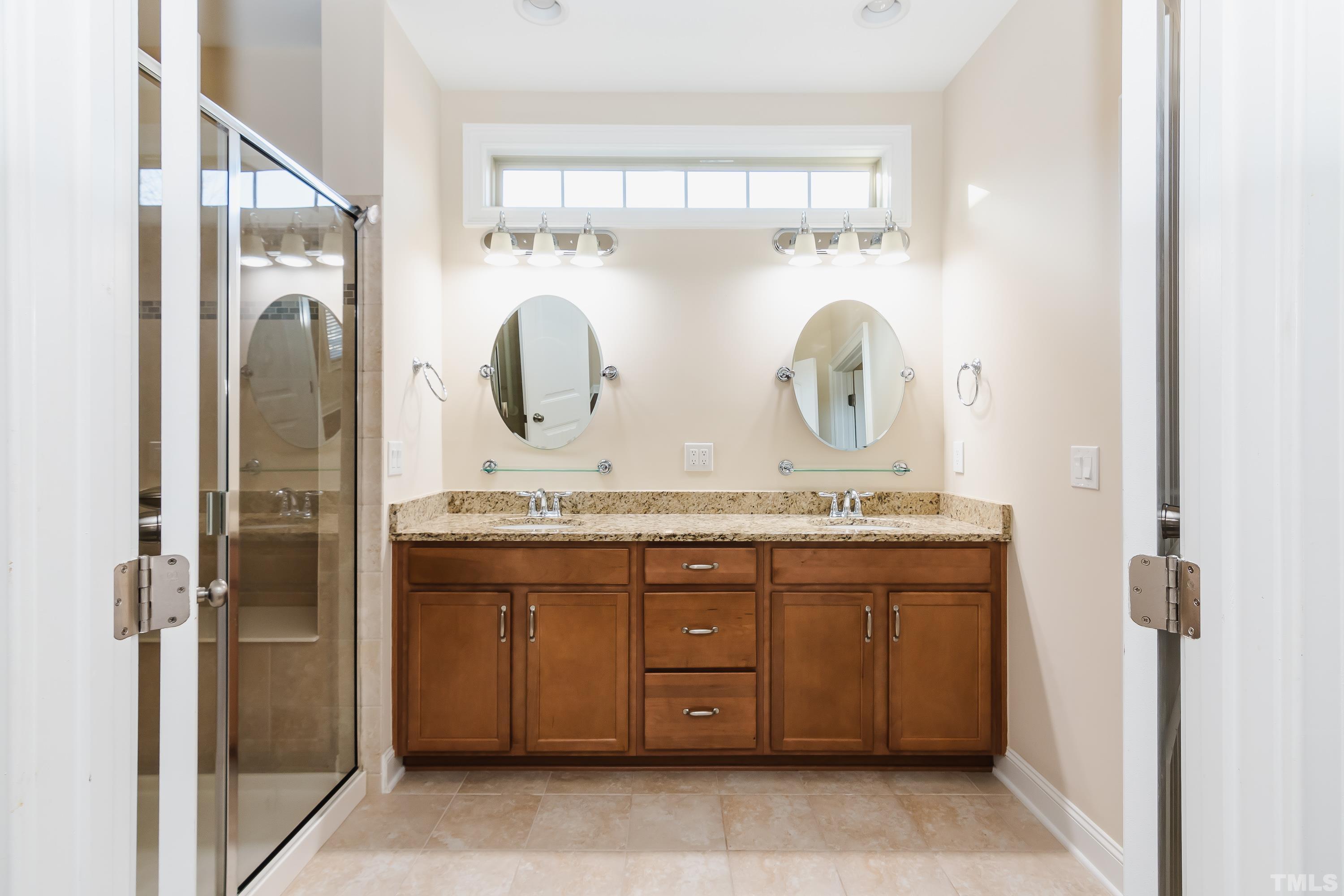 821 Traditions Ridge Drive Wake Forest, NC 27587 - Photo 10 of 14 a bathroom with a granite countertop sink a mirror and a shower