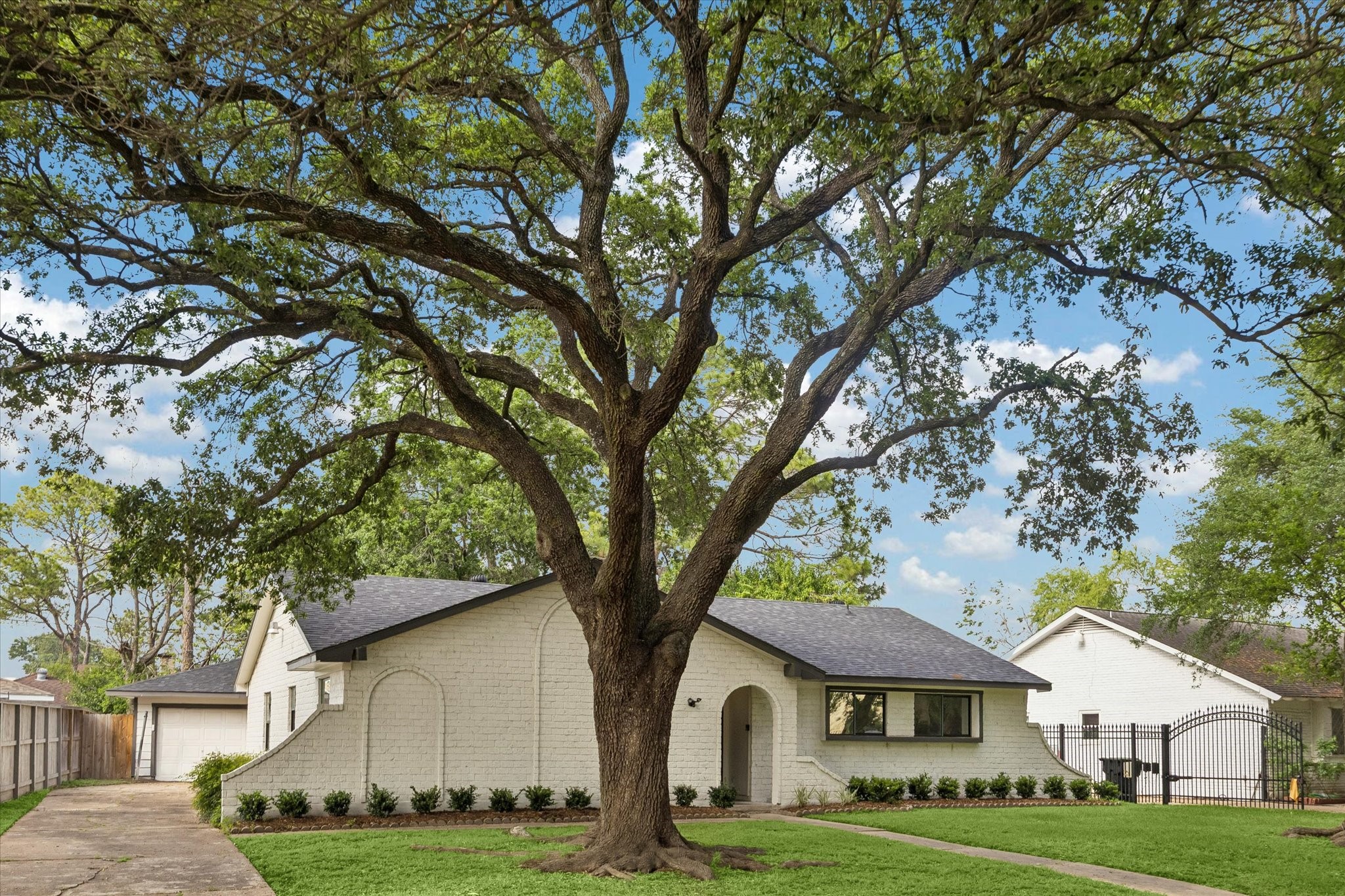 7802 Gulfton Street Houston, TX 77036 - Photo 2 of 20 a front view of a house with a garden