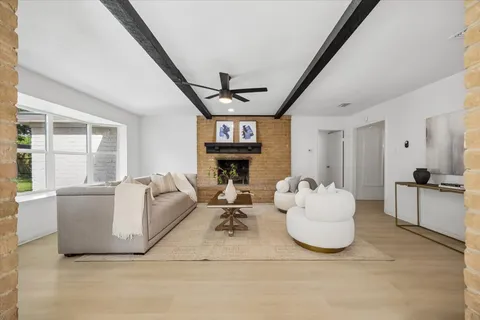 a living room with fireplace furniture and a large window