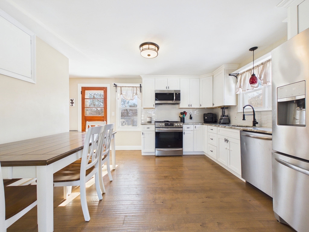 112 Lawson Avenue Acushnet, MA 02743 - Photo 14 of 28 a kitchen with stainless steel appliances granite countertop a stove top oven a sink dishwasher and a refrigerator with wooden floor