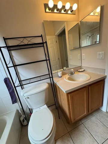 a bathroom with a sink a toilet a mirror and bathtub