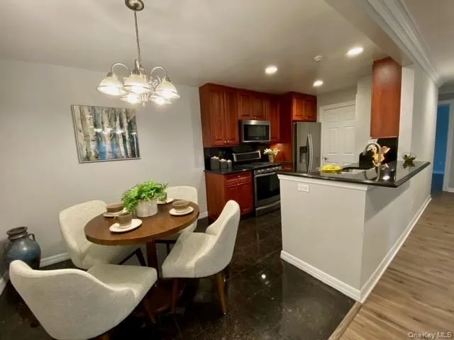 a view of a dining room with furniture a kitchen and chandelier