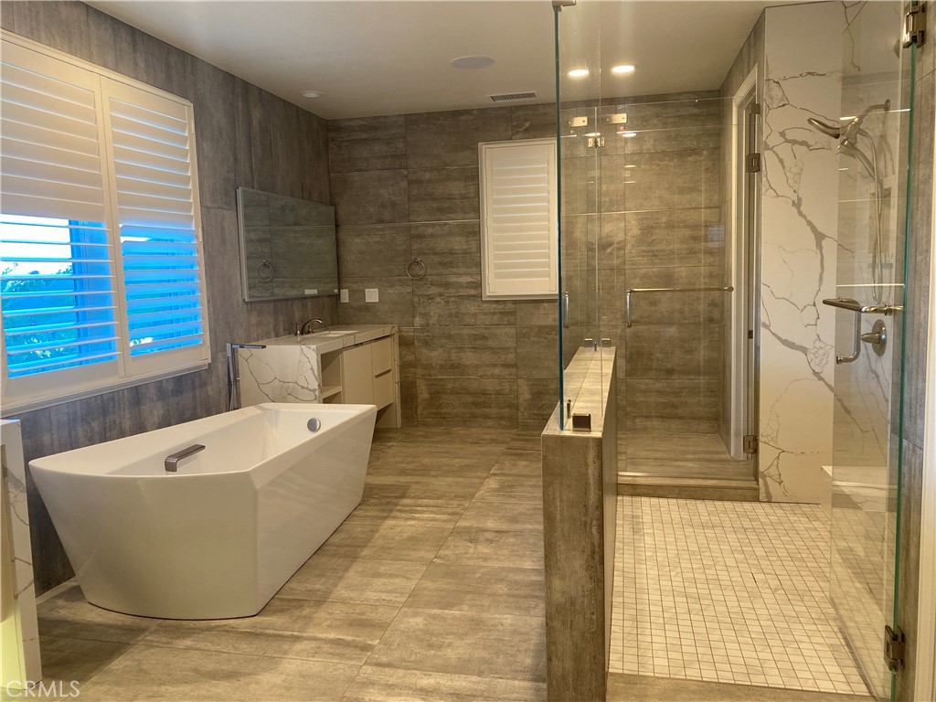 107 Iron Gate Irvine, CA 92618 - Photo 19 of 37 a bathroom with a bathtub and shower