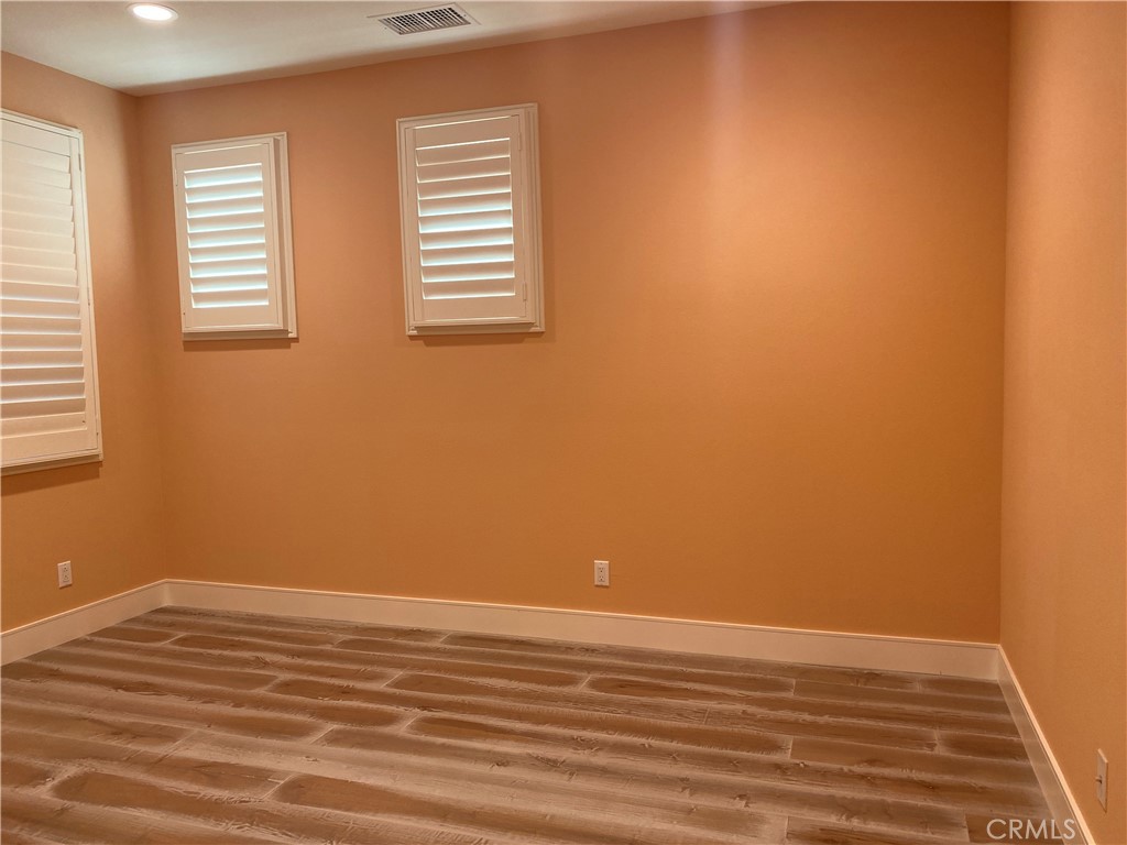 107 Iron Gate Irvine, CA 92618 - Photo 21 of 37 a view of an empty room with wooden floor and a window