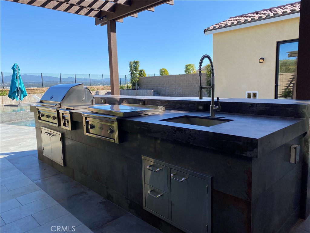 107 Iron Gate Irvine, CA 92618 - Photo 33 of 37 a kitchen with stainless steel appliances granite countertop a sink a stove and a refrigerator