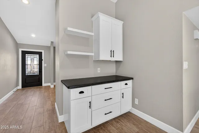 a kitchen with granite countertop a stove and a wooden floors