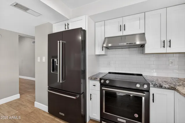 a kitchen with cabinets and stainless steel appliances