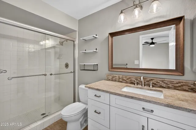 a bathroom with a granite countertop sink toilet and shower