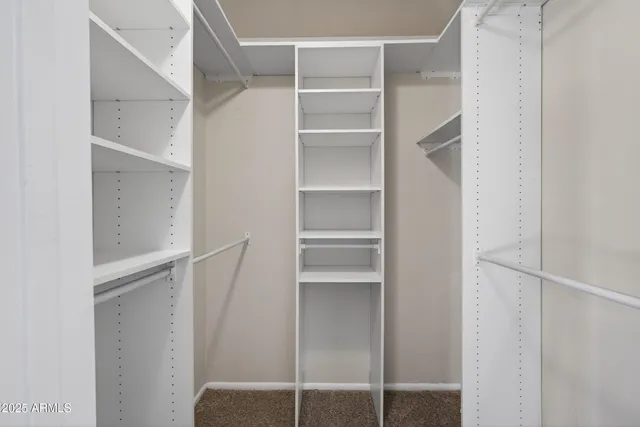 a view of walk in closet with empty racks