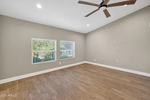 a view of a big room with wooden floor and fan