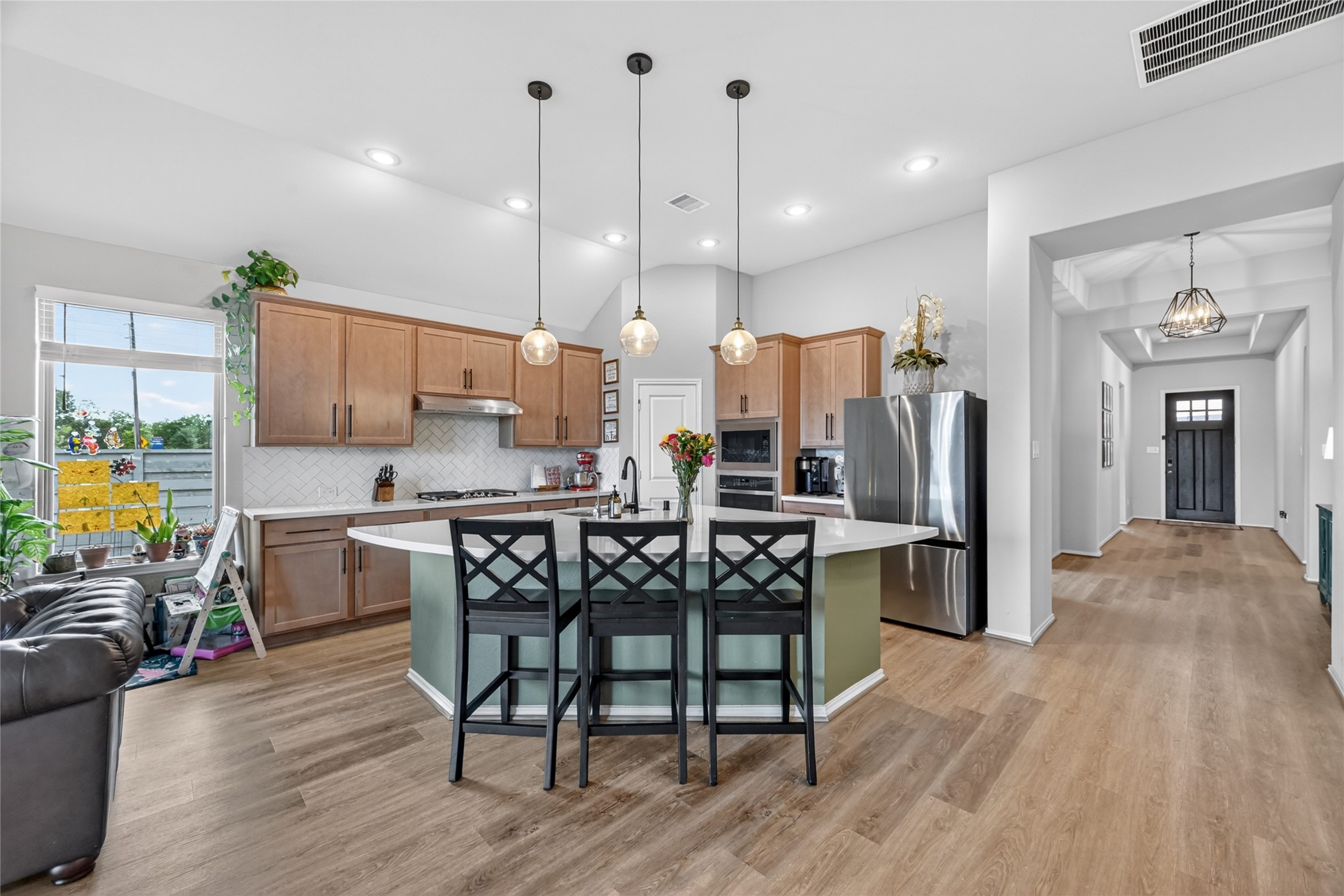 4731 Cedar Butte Lane Manvel, TX 77578 - Photo 12 of 42 a kitchen with stainless steel appliances a dining table chairs stove refrigerator and cabinets
