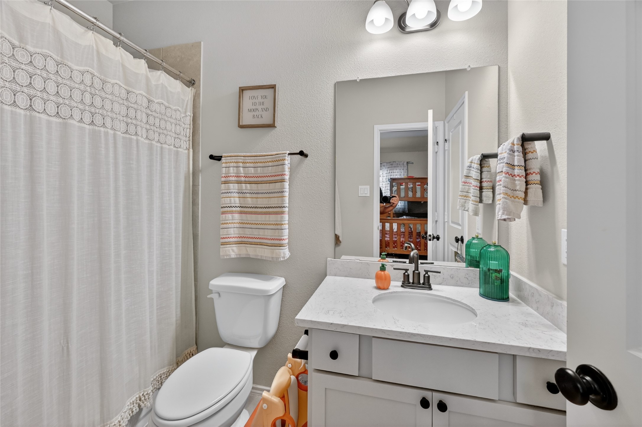 4731 Cedar Butte Lane Manvel, TX 77578 - Photo 31 of 42 a bathroom with a sink a toilet and shower curtain