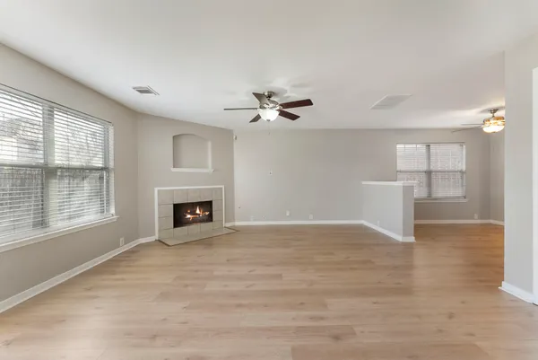 a view of an empty room with a fireplace and a window