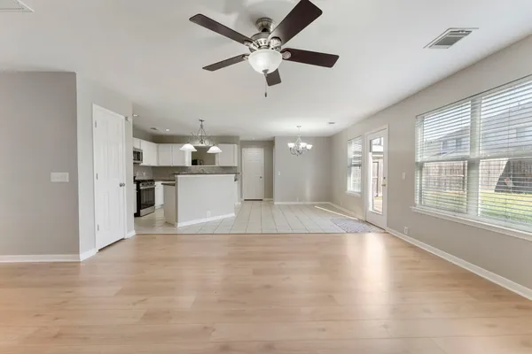 a view of an empty room with kitchen appliances and a window
