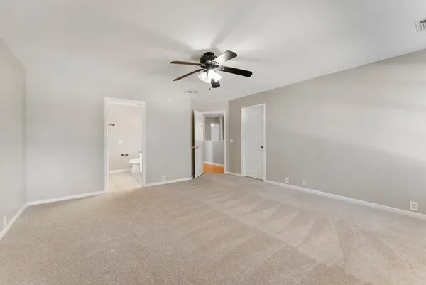 a view of a big room with chandelier fan and windows
