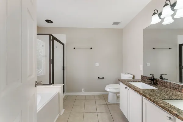 a bathroom with a granite countertop sink a toilet and shower