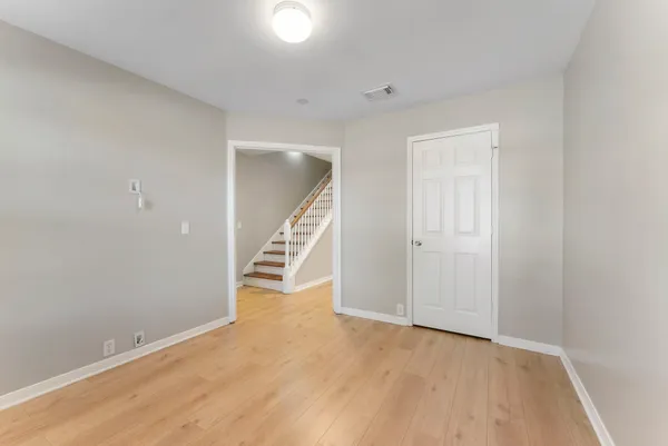 an empty room with wooden floor and staircase