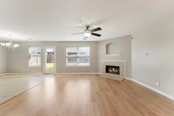 a view of an empty room with a fireplace and a window