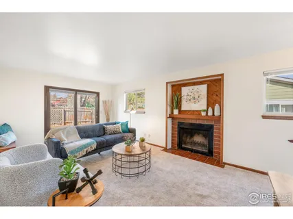 a living room with furniture a fireplace and a window