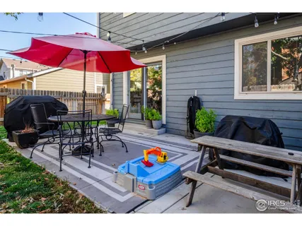 a view of backyard with outdoor seating and wooden fence