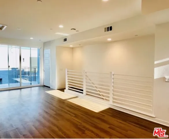 a view of a room with wooden floor and windows