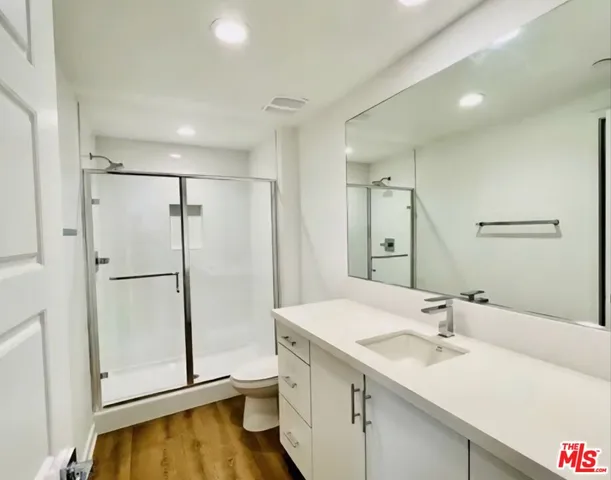 a bathroom with a double vanity sink mirror and shower
