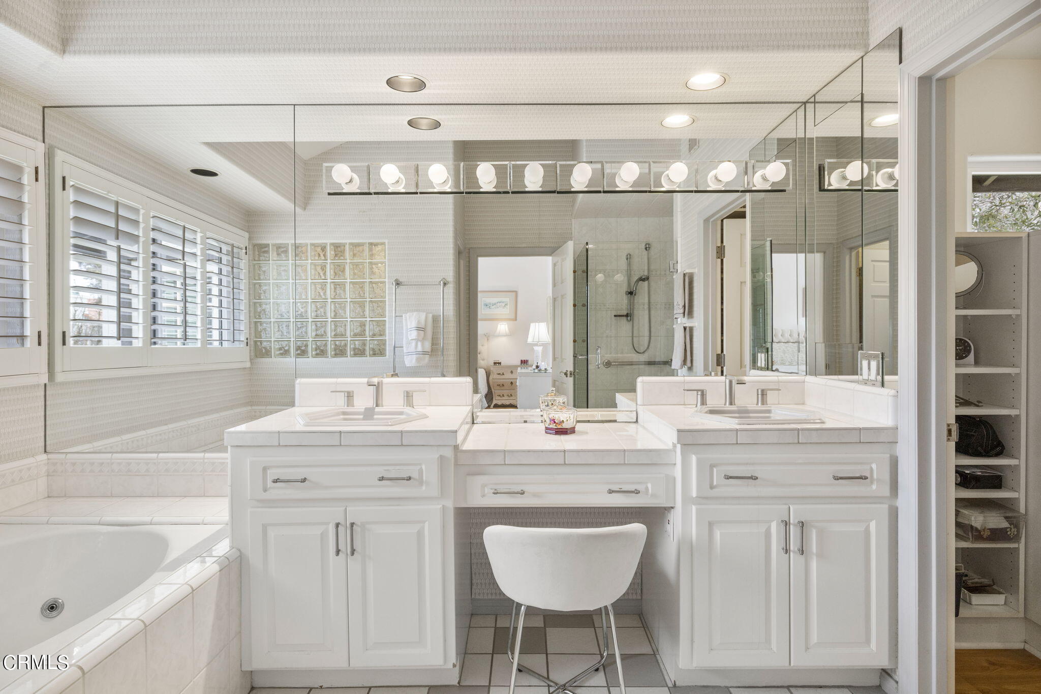 2226 Cannes Square Oxnard, CA 93035 - Photo 36 of 75 a bathroom with a double vanity sink a mirror a bathtub and next to a window