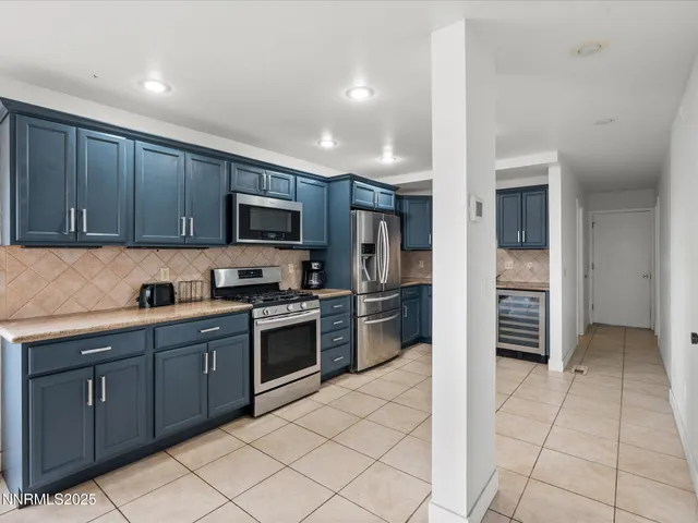 a kitchen with stainless steel appliances granite countertop a refrigerator and a stove top oven