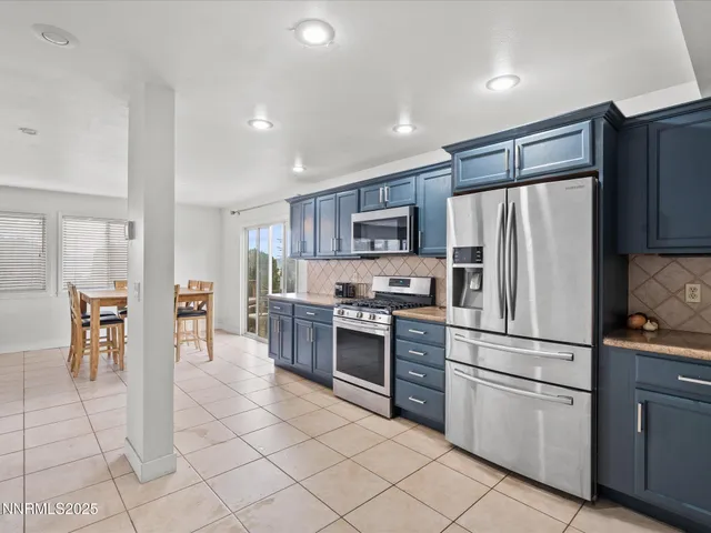 a kitchen with stainless steel appliances granite countertop a refrigerator and a stove top oven