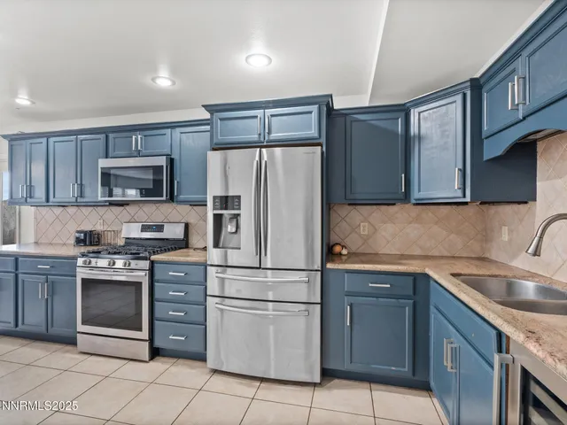 a kitchen with granite countertop cabinets stainless steel appliances and a sink