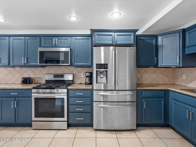 a kitchen with granite countertop wooden cabinets and stainless steel appliances