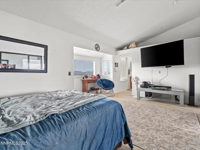 a bedroom with a bed and a television