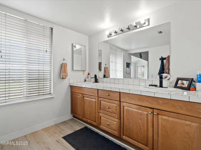 a spacious bathroom with a double vanity sink and mirror