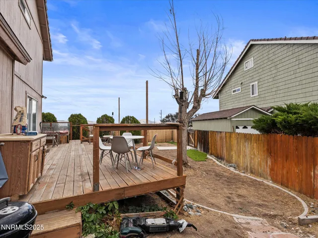 a view of a roof deck with table and chairs a barbeque with wooden floor and fence