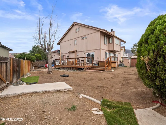 a view of a white house with large windows and a yard