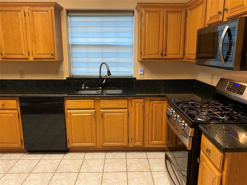 1924 Sunset Path Lewisville, TX 75067 - Photo 12 of 37 a kitchen with granite countertop cabinets and black appliances