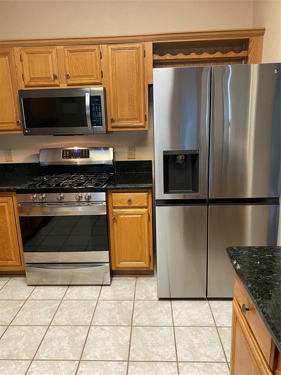 1924 Sunset Path Lewisville, TX 75067 - Photo 35 of 37 a kitchen with granite countertop a stove and a microwave