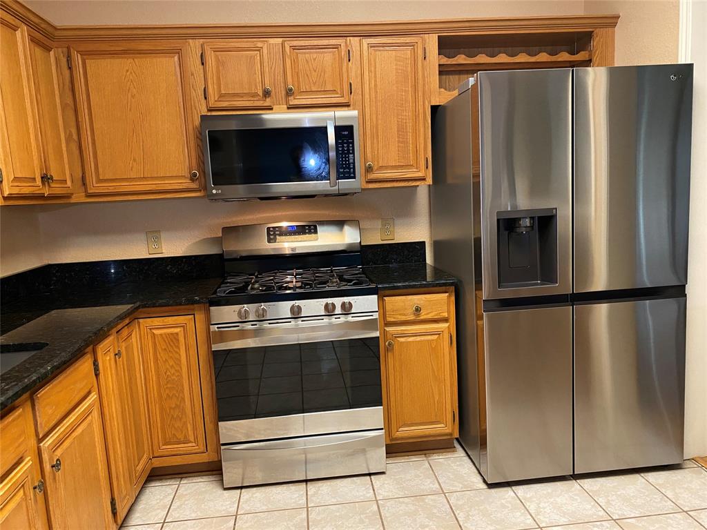 1924 Sunset Path Lewisville, TX 75067 - Photo 36 of 37 a kitchen with stainless steel appliances granite countertop a refrigerator and a stove top oven