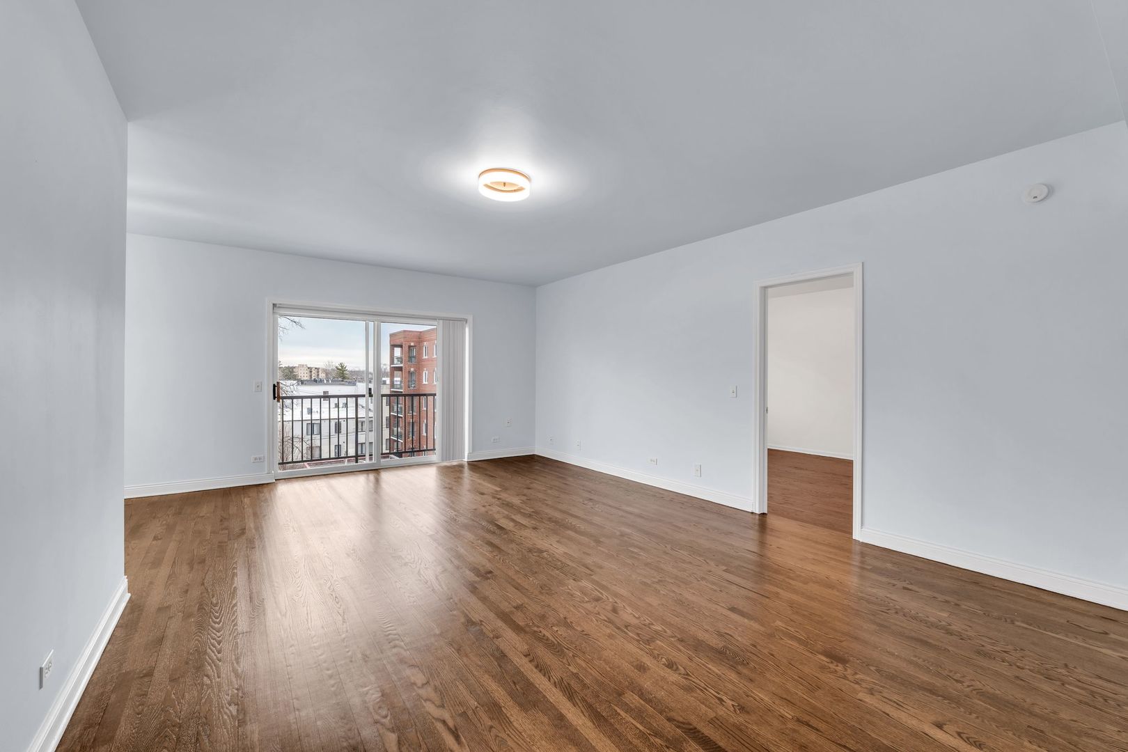 1330 Perry Street, Unit 504 Des Plaines, IL 60016 - Photo 12 of 32 a view of an empty room with wooden floor and a window