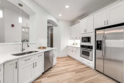 a kitchen with white cabinets and white appliances