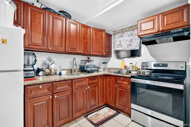 a kitchen with stainless steel appliances granite countertop a stove top oven a sink dishwasher and cabinets with wooden floor