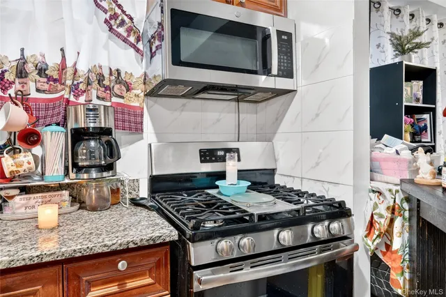a kitchen with stainless steel appliances granite countertop a stove and a microwave