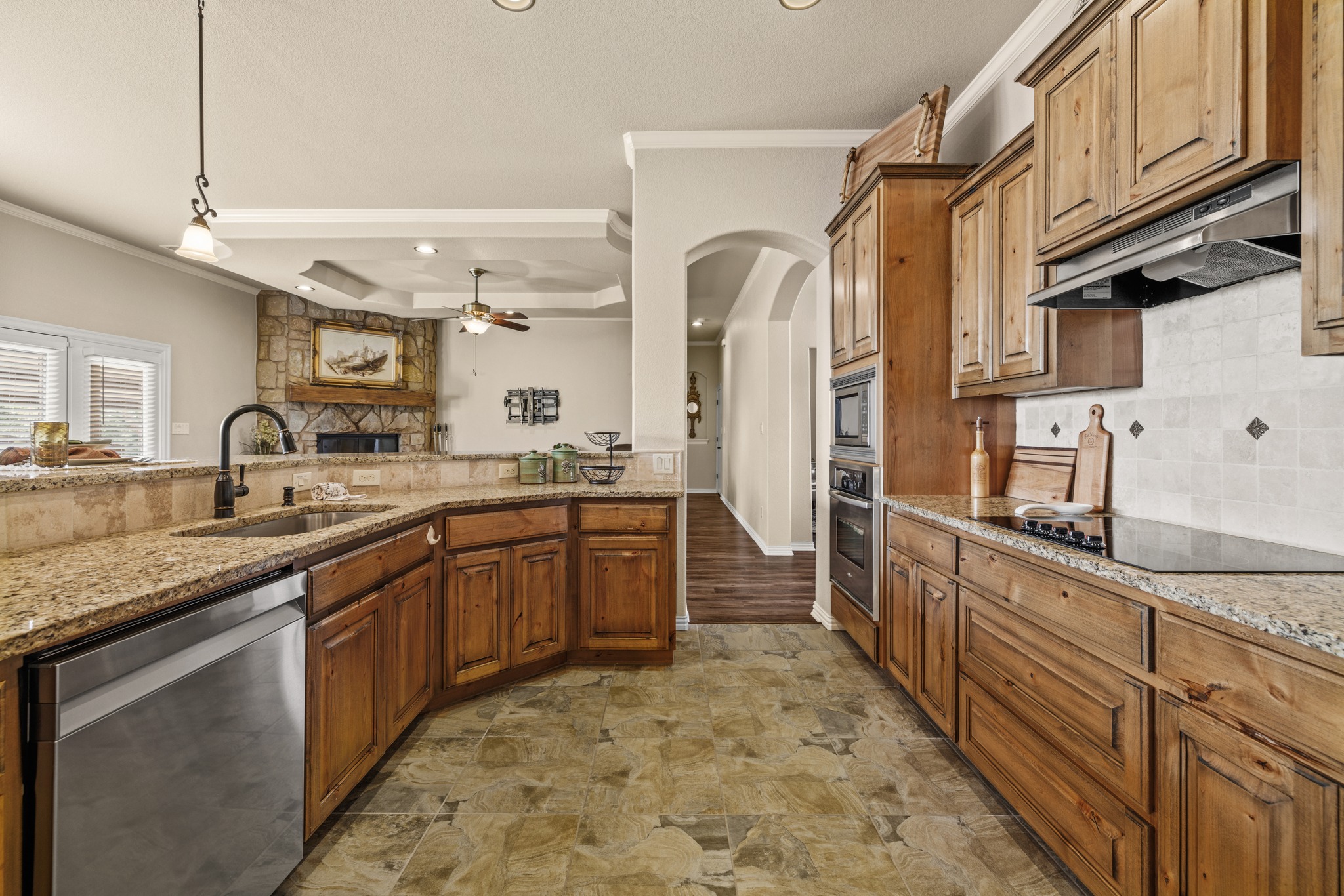 204 Skyline Road Georgetown, TX 78628 - Photo 17 of 40 Kitchen featuring stainless steel appliances, light stone countertops, crown molding, decorative light fixtures, and ceiling fan