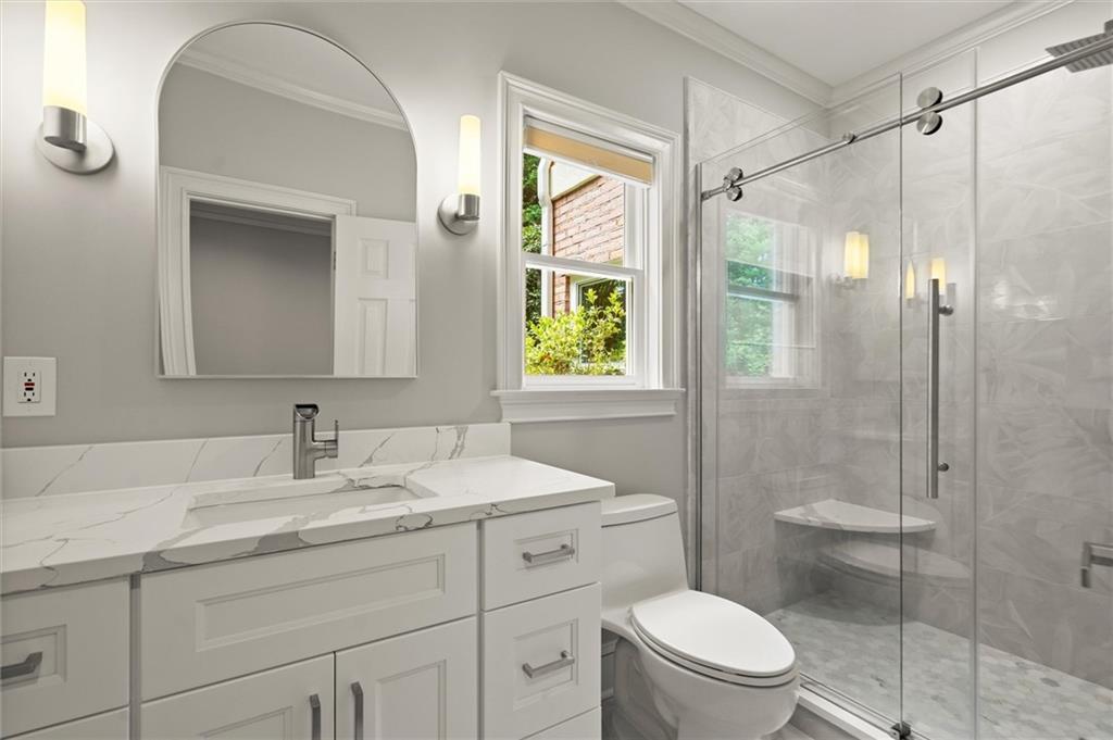 1200 Bay Pointe Terrace Alpharetta, GA 30005 - Photo 42 of 56 a bathroom with a toilet a sink a glass door a shower a mirror and vanity