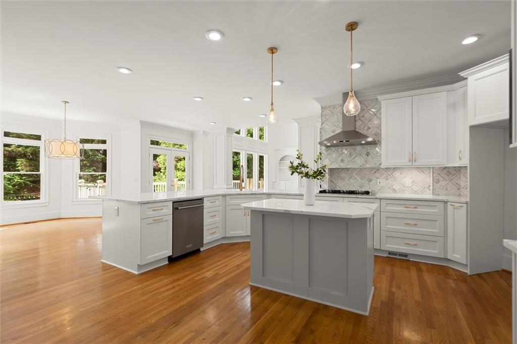 1200 Bay Pointe Terrace Alpharetta, GA 30005 - Photo 10 of 56 a kitchen with stainless steel appliances granite countertop a sink a stove a refrigerator and white cabinets with wooden floor
