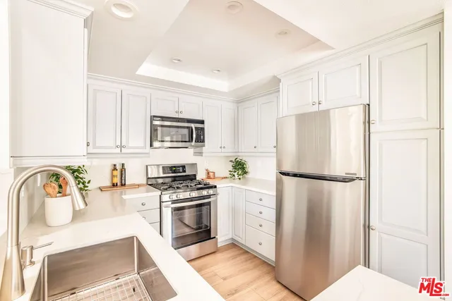 a kitchen with stainless steel appliances a refrigerator sink and stove