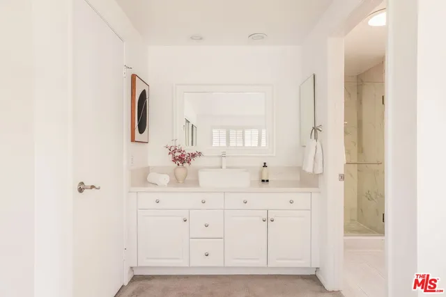 a bathroom with a sink a mirror and a shower