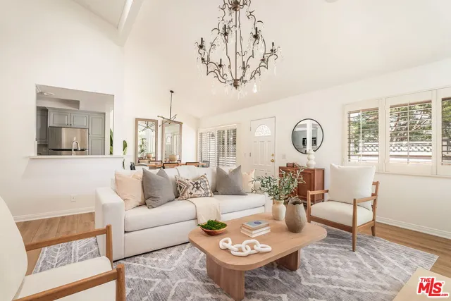 a living room with furniture a large window and a table