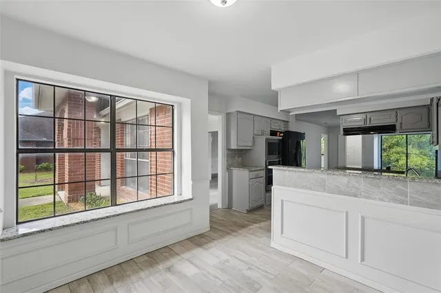 an empty room with wooden floor and ceiling fan