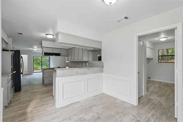 a view of a kitchen with wooden floor and a window